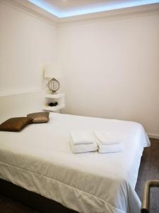 a bedroom with a white bed with two towels on it at Sintra Design Apartment _ Castelo dos Mouros in Sintra