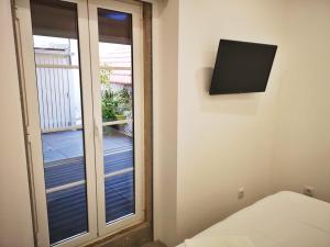 a room with a window and a tv on the wall at Sintra Design Apartment _ Castelo dos Mouros in Sintra