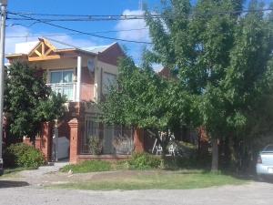a red brick house with a tree in front of it at Casa de Franchesca HOSTEL in Trelew
