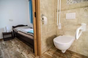 a bathroom with a toilet and a bed at Čičina Tvrdonice penzion, restaurace, vinný sklep in Tvrdonice