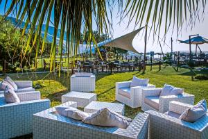 a group of white chairs and tables in a yard at Aregai Marina Hotel & Residence in Santo Stefano al Mare