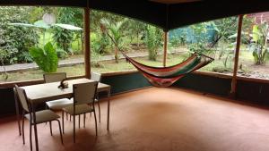 a room with a hammock and a table and chairs at Centro Ananda in Guápiles