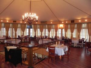a restaurant with tables and chairs and a chandelier at Hestia Hotel in Călăraşi