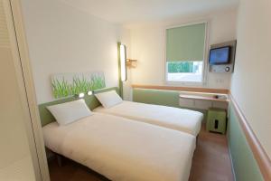 a small room with two beds and a window at ibis budget Cherbourg - La Glacerie in Cherbourg en Cotentin +90 photos