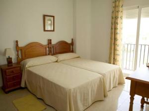 um quarto com uma cama, uma cómoda e uma janela em Apartamentos Miguel Angel em Estepona