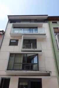 a tall white building with windows at Apartamento Enol in Cangas de Onís