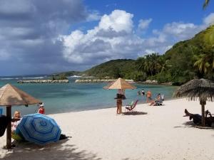 a group of people on a beach with umbrellas at COZY Studio 331 ADR in Saint-François