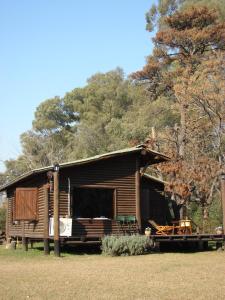 a log cabin with a porch and a table and chairs at Cabañas Las Lavandas en Pilar in Pilar