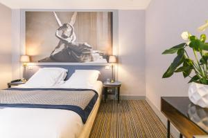 Cette chambre d'hôtel dispose d'un lit avec une statue au-dessus. dans l'établissement Hotel Saint Christophe, à Paris