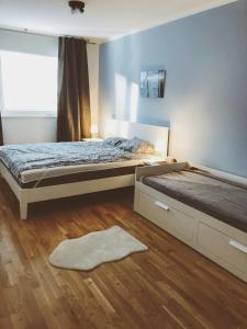 a bedroom with two beds and a window and a rug at BestVienna U1 Kagran/DZ in Vienna