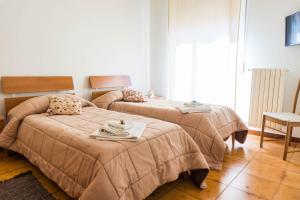a bedroom with two beds with a table and a chair at B&B Ulisse in Ispica