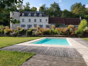 a large house with a swimming pool in front of it at Gite de la Vigneraie in Athée-sur-Cher