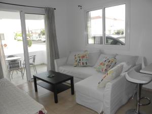 ein Wohnzimmer mit einem weißen Sofa und einem Tisch in der Unterkunft Cosy apartment in a luxury resort in Paralimni