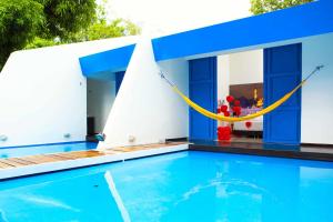 ein Haus mit einem Pool und einer gelben Hängematte in der Unterkunft Hotel y Spa Santa Fe Colonial in Santa Fe de Antioquia