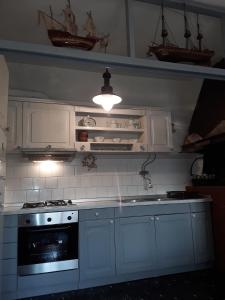 a kitchen with white cabinets and a stove top oven at Adorable Summer house by the sea in Zapuntelo