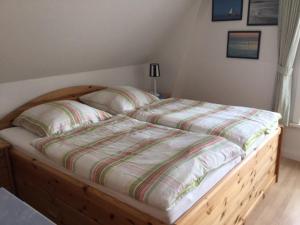 ein Bett mit einem Holzrahmen in einem Schlafzimmer in der Unterkunft Theodor Storm Unterkünfte 2 in Husum
