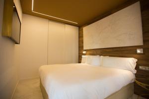 um quarto com uma cama branca e um quadro na parede em Boulevard Luxury by Sebastiana Group em San Sebastián