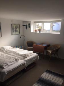 1 Schlafzimmer mit 2 Betten, einem Schreibtisch und einem Fenster in der Unterkunft Ebeltoft-rooms in Ebeltoft