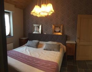 a bedroom with a large bed and a chandelier at Casa della Nonna in Zwalm
