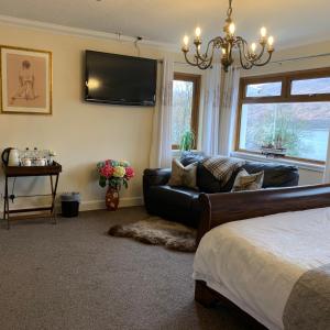 a bedroom with a couch and a tv on the wall at Westcourt Bed & Breakfast in Fort William