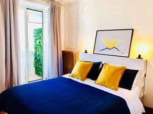 una camera da letto con un letto blu e bianco con cuscini gialli di Civico Vesuvio B&B a Napoli