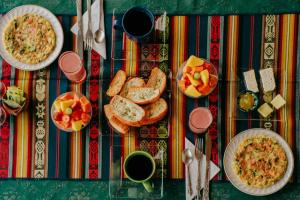 una mesa con platos de comida y tazas de café en Hotel Casa Alquimia, en Quito