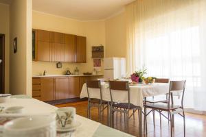 a kitchen with a table and chairs and a kitchen with a refrigerator at B&B Ulisse in Ispica