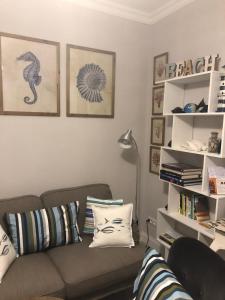 a living room with a couch and a shelf with books at A cà da Alba Rooms in Monterosso al Mare