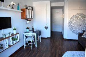 Una pequeña sala de estar con una mesa y sillas. en BENALBEACH DELUXE, en Benalmádena