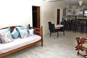 a living room with a couch and a dining room at Golden Beach Resort A051 in Diani Beach