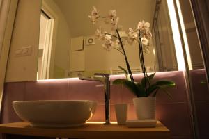 a bathroom with a sink and a vase with flowers at Arco della Rua in Amalfi +44 photos