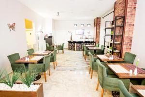 a dining room with wooden tables and green chairs at The Corner Inn Hotels By Suit in Eskisehir