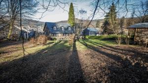 a large house in a yard with its shadows on the ground at Gites La Tabatiere in Vresse-sur-Semois