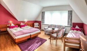 ein Schlafzimmer mit einem Bett, einem Stuhl und einem Tisch in der Unterkunft Villa Wilisch in Amtsberg