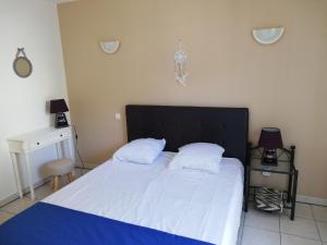 パトリモニオにあるChambres d'hôtes Multariのベッドルーム1室(大型ベッド1台、黒いヘッドボード付)