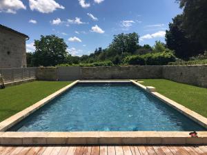 a swimming pool in a yard with a wooden deck at Chateau de Maumont in Magnac-sur-Touvre