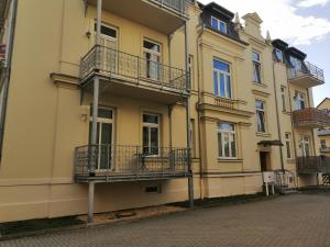 a yellow building with balconies on a street at Ferienwohnung Kopp V in Greiz