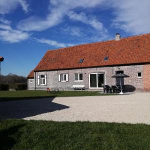 um grande edifício de tijolos com telhado vermelho em Hauwaertshoeve em Beernem