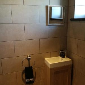 a small bathroom with a sink and a mirror at Hauwaertshoeve in Beernem