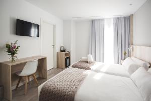 a hotel room with a bed and a desk and a television at DWO Ábaster in Soria