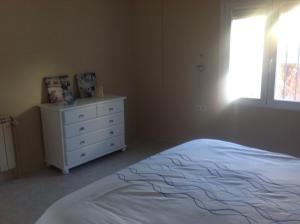 a bedroom with a bed and a dresser and a window at Casa Pauline in Benissa