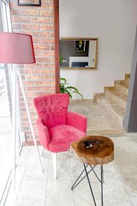 una silla roja y una mesa de madera en una habitación en The Corner Inn Hotels By Suit, en Eskisehir