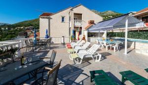 a patio with tables and chairs and a pool at Villa Arka in Cavtat