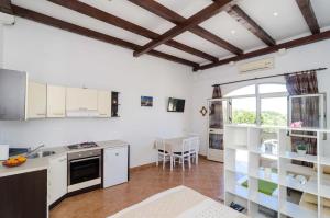 a kitchen with white cabinets and a large window at Villa Arka in Cavtat
