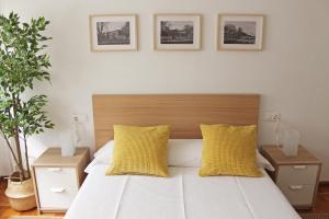 ビラガルシーア・デ・アロウサにあるApartamento Vilagarcía de Arousaのベッドルーム1室(黄色い枕のベッド1台付)