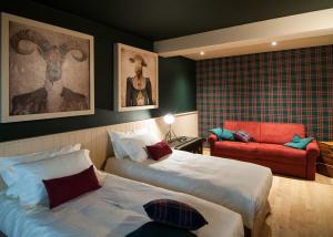 ゴリツィアにあるKlanjscek Wine&Stayのベッド2台と赤い椅子が備わるホテルルームです。