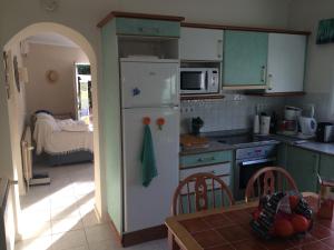 a kitchen with green cabinets and a white refrigerator at Casa Pauline in Benissa