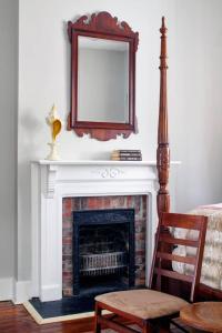 a fireplace with a mirror and a chair in a room at 414 Waldburg A · Newly Renovated Apt with outdoor space! in Savannah