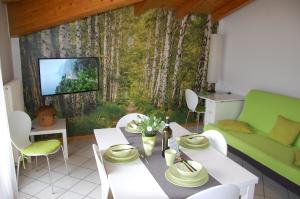 リーヴァ・デル・ガルダにあるAppartamento Betullaのリビングルーム(テーブル、緑のソファ付)