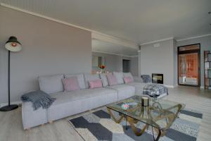 ein Wohnzimmer mit einem Sofa und einem Glastisch in der Unterkunft Ocean Blue Apartment & Studio in Monte Estoril